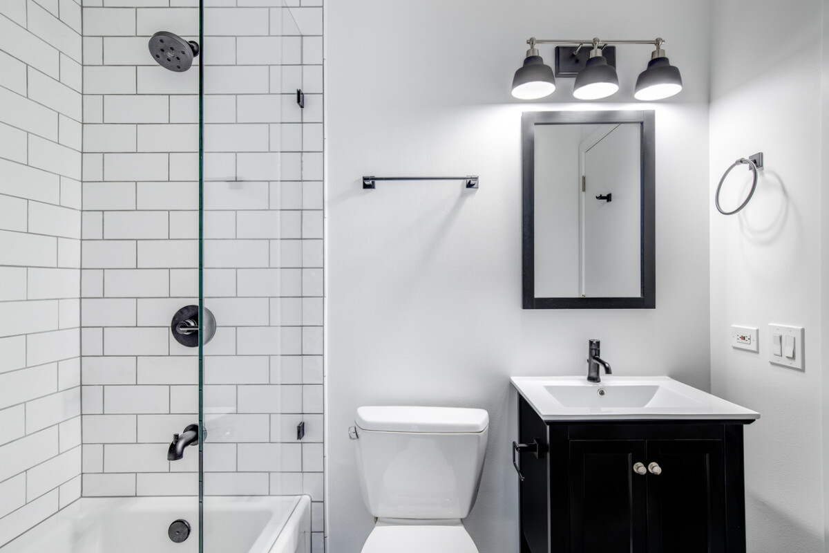 Bathroom with a black cabinet, white subway tiles, and modern fixtures.