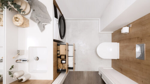 Organised bathroom space with cosmetics and towels neatly stored in a cupboard box.