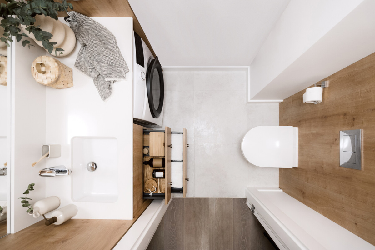 Organised bathroom space with cosmetics and towels neatly stored in a cupboard box.