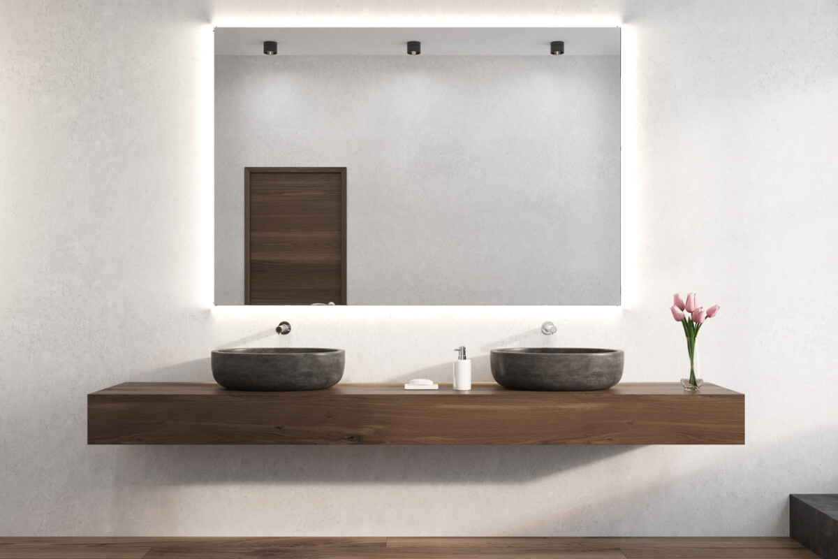 White bathroom with double sinks and a large mirror on the wall.